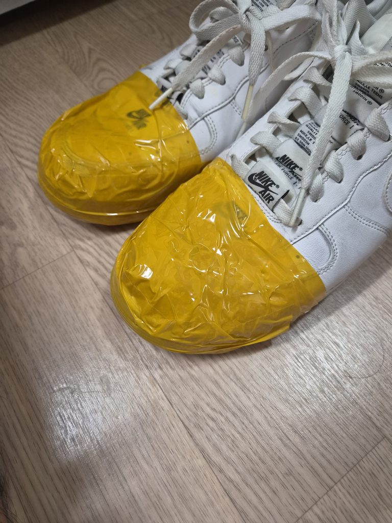 앞부분에 노란 테이프를 감아 둔 운동화 한 켤레