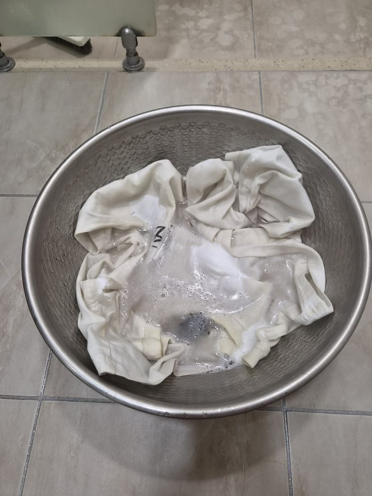 거품이 생긴 세탁물에 흰 티셔츠를 담가 둔 모습